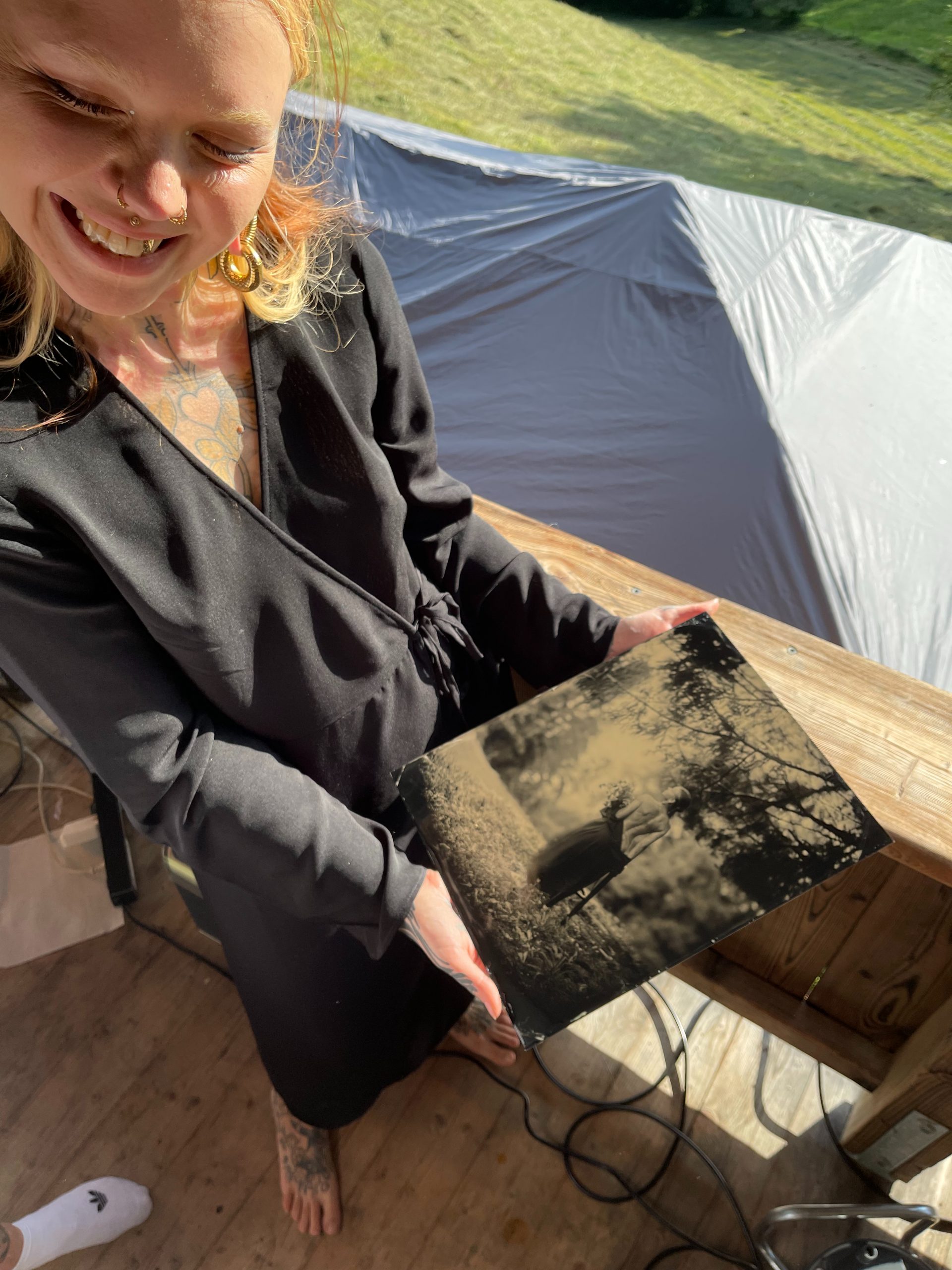 Gast hält frisches Tintype in den Händen — handgemachte Fotografie auf Events